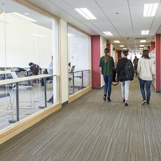 Students walking past the reading room in Old Main.